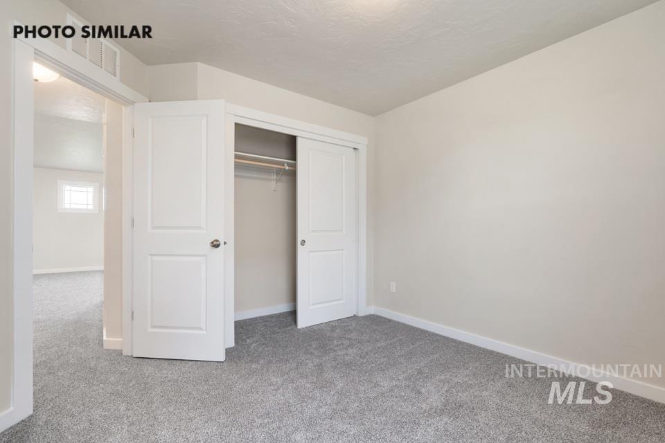 1693 Rapid Road Emmett, ID 83617 - Photo 23 of 28 Carpeted room featuring a built-in closet with sliding doors and an additional entry door