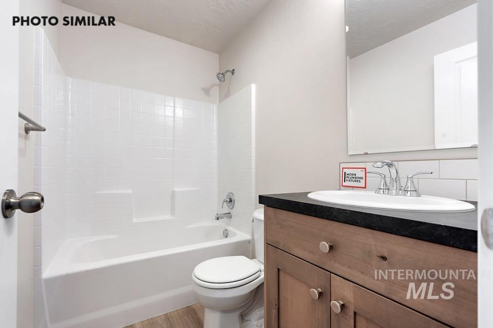 1693 Rapid Road Emmett, ID 83617 - Photo 24 of 28 Bathroom featuring a wood-finish vanity with a dark countertop and an undermount sink