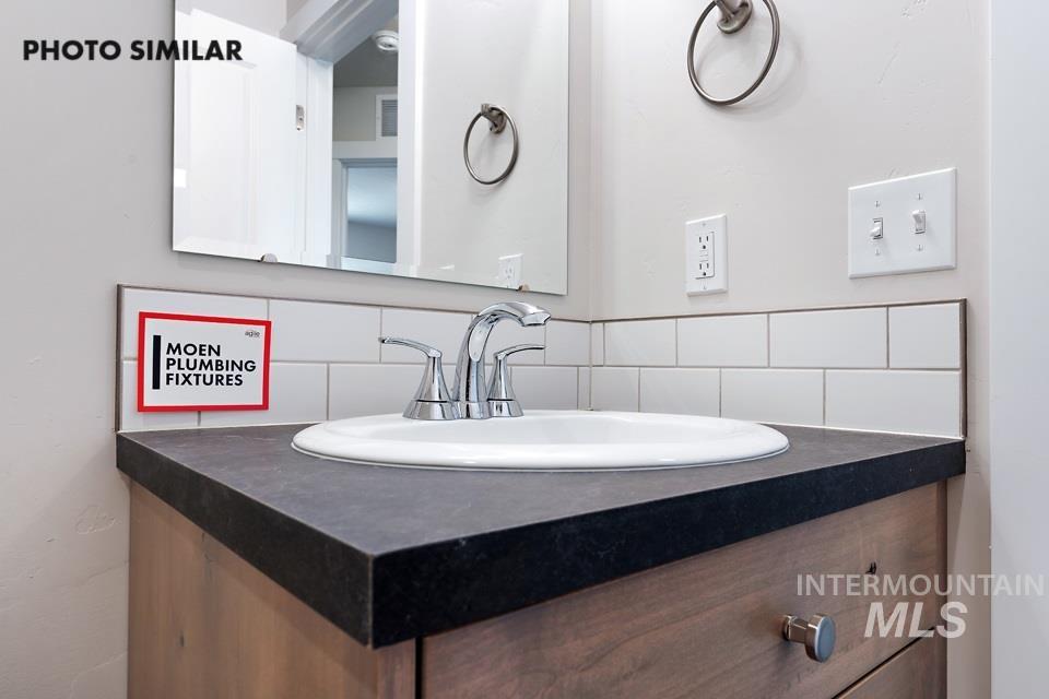 1693 Rapid Road Emmett, ID 83617 - Photo 25 of 28 Bathroom vanity featuring a dark countertop, undermount sink, and chrome faucet