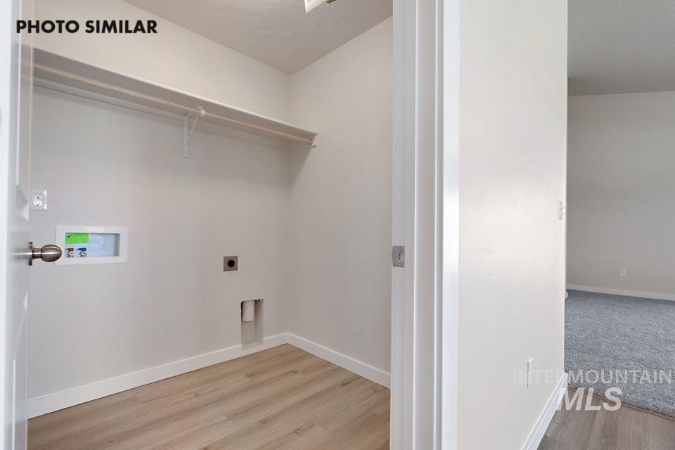 1693 Rapid Road Emmett, ID 83617 - Photo 26 of 28 Dedicated laundry area featuring wood-finish flooring, white walls, and a white storage shelf