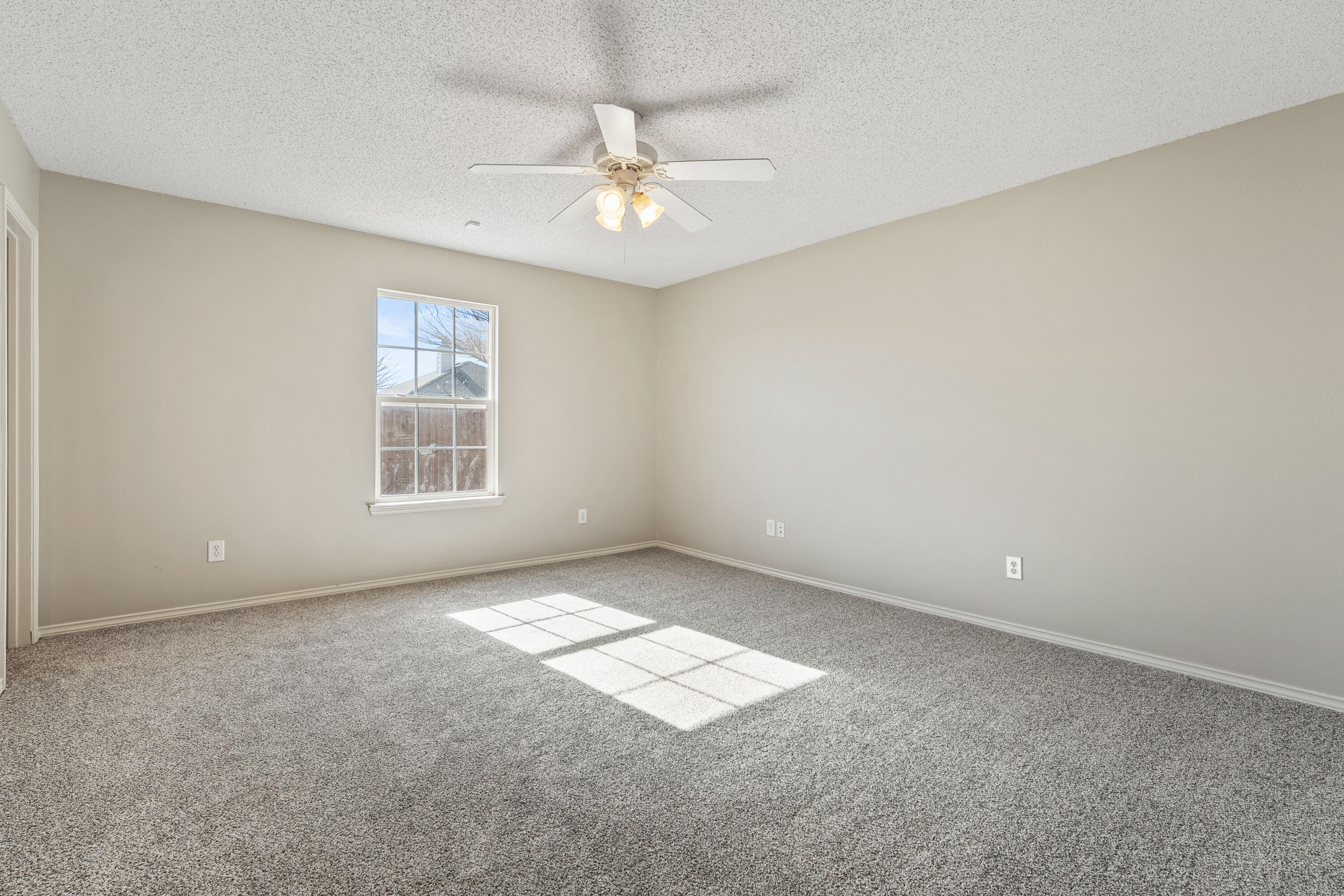 6517 91st Street Lubbock, TX 79424 - Photo 5 of 11 an empty room with windows and fan