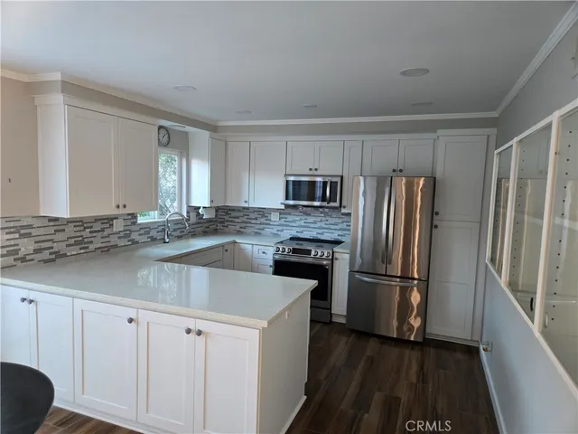 a kitchen with granite countertop a refrigerator and a sink