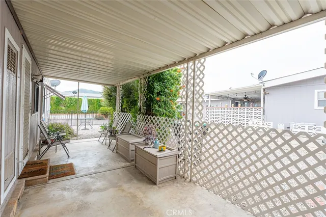 a view of a chairs and table in patio next to a yard