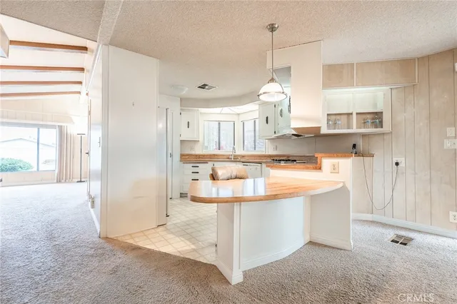 a kitchen with kitchen island granite countertop a sink and a refrigerator