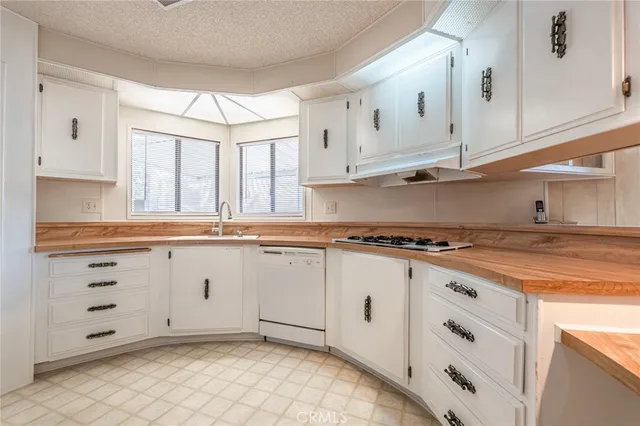 a kitchen with granite countertop white cabinets and white appliances