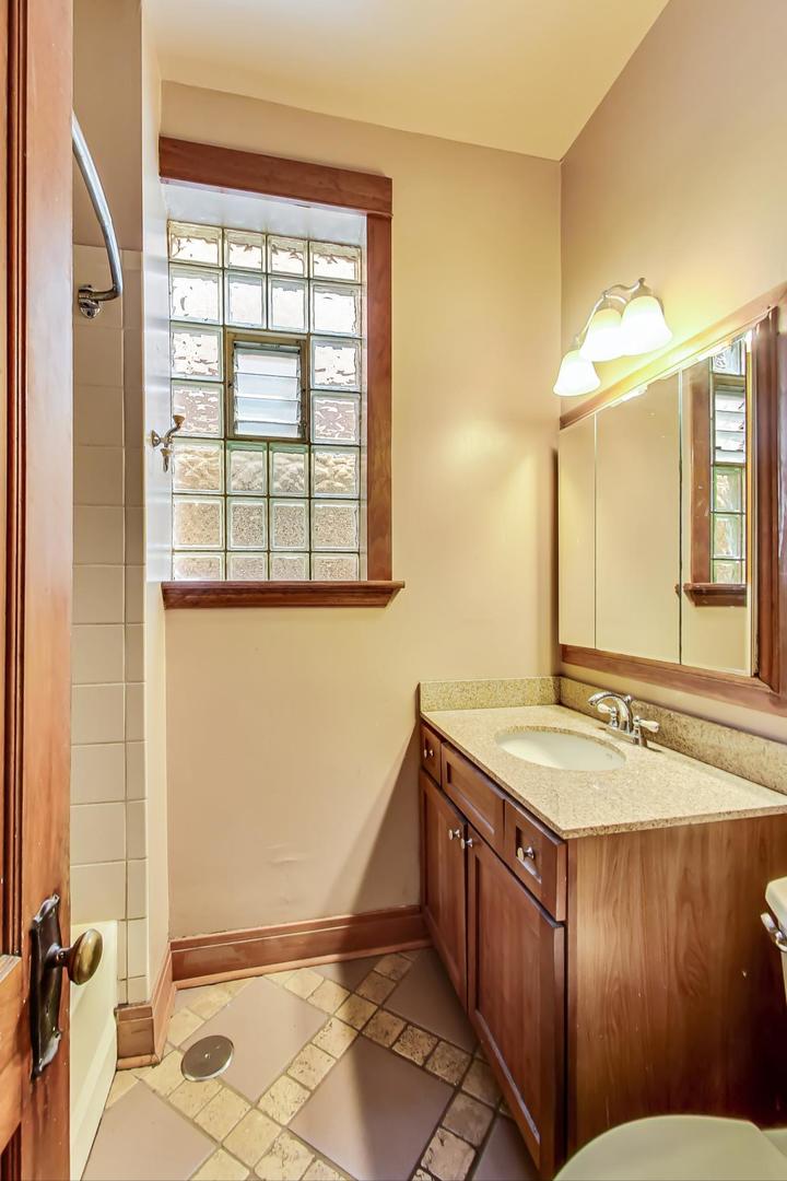 2145 West Thomas Street, Unit 2 Chicago, IL 60622 - Photo 11 of 14 a bathroom with a granite countertop sink and a mirror