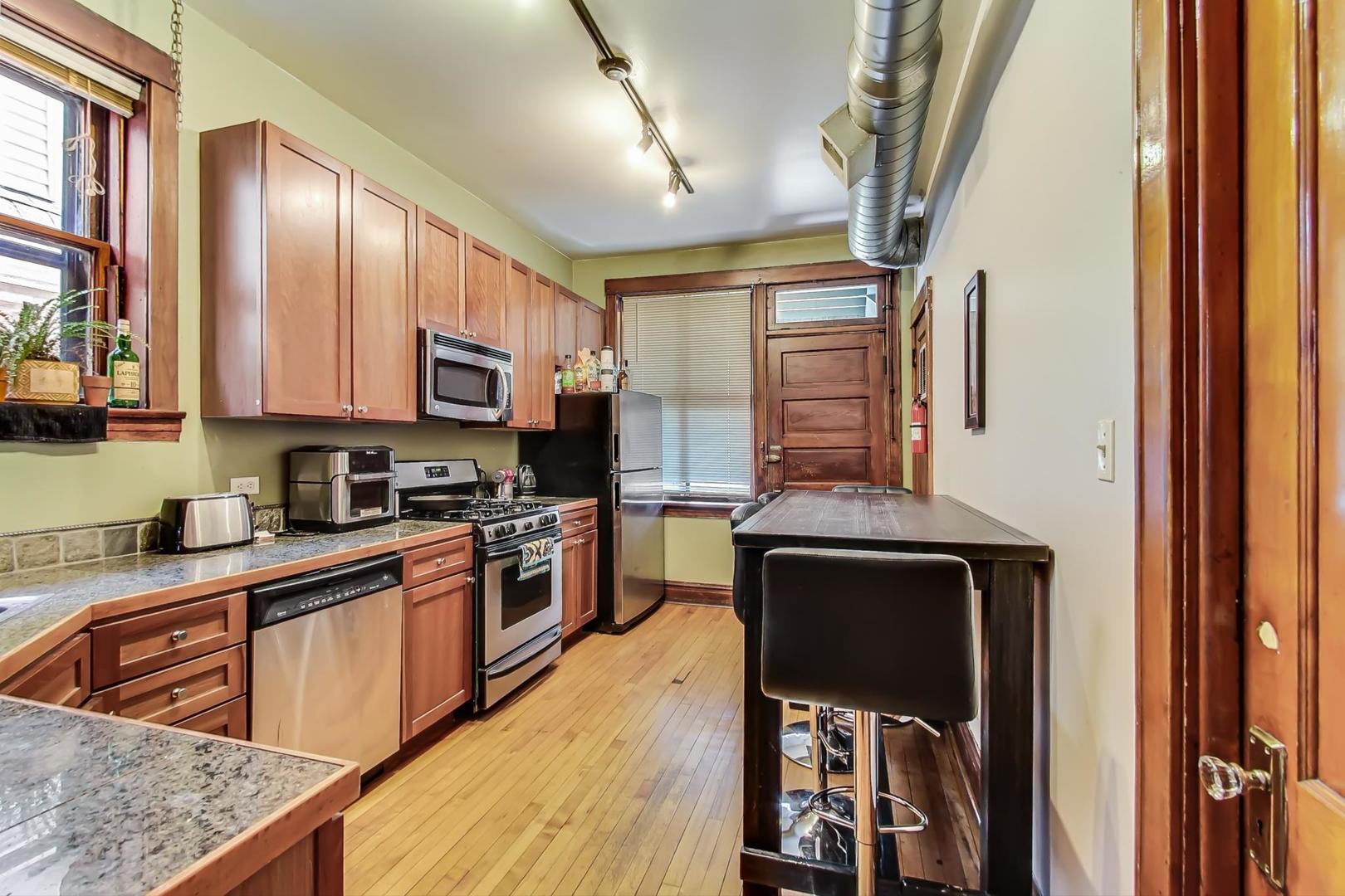 2145 West Thomas Street, Unit 2 Chicago, IL 60622 - Photo 10 of 14 a kitchen with stainless steel appliances granite countertop a sink stove and refrigerator