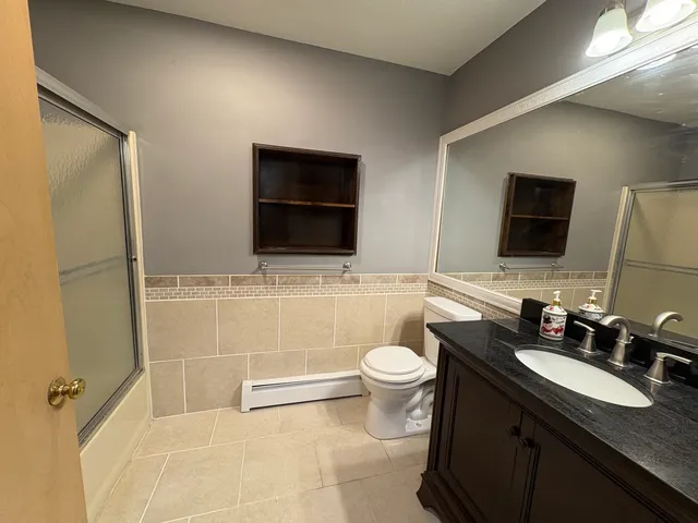 a bathroom with a toilet a sink and mirror