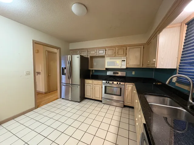 a kitchen with granite countertop a refrigerator and a sink