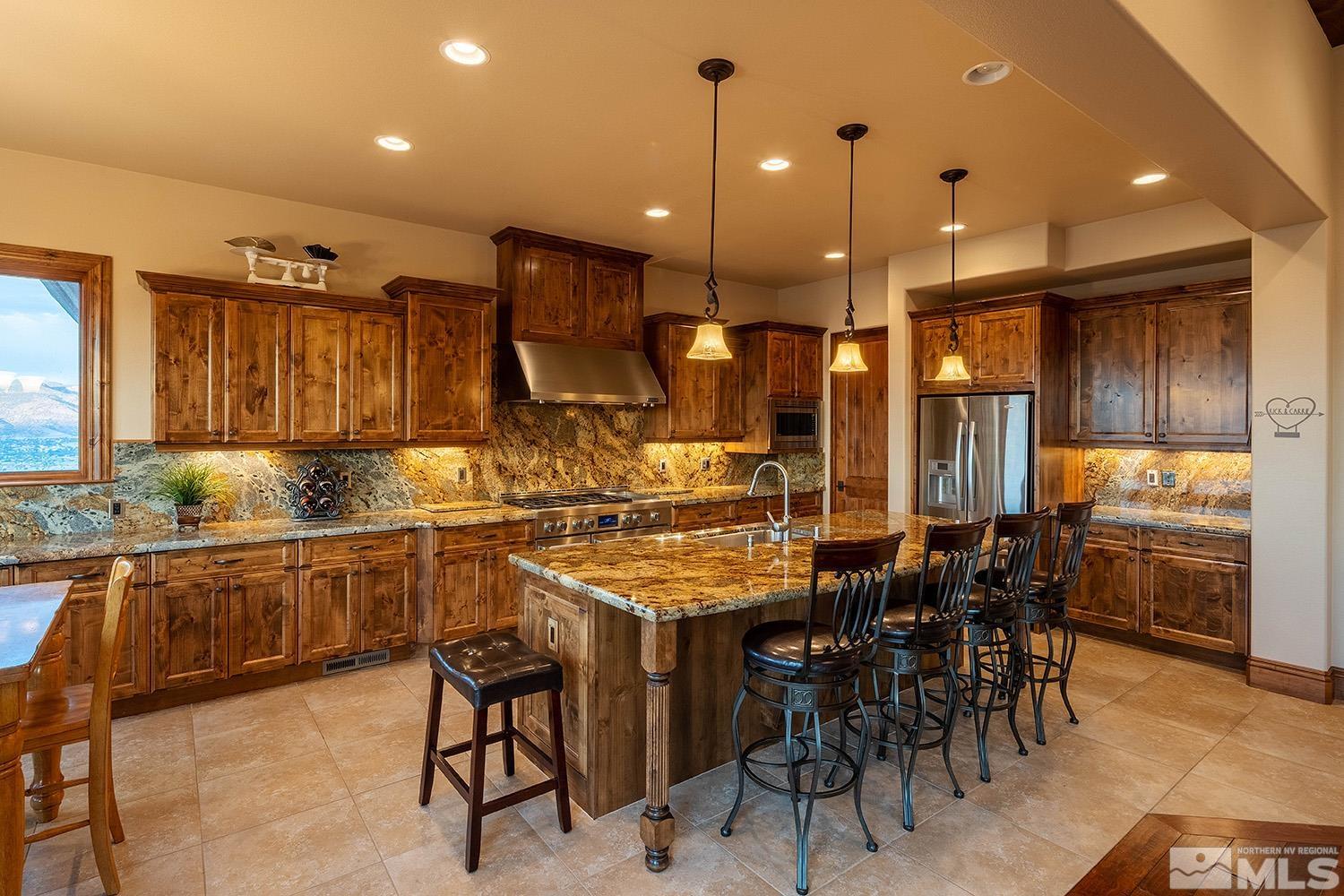 3745 Boulder Patch Reno, NV 89511 - Photo 31 of 40 a kitchen with stainless steel appliances kitchen island granite countertop a table chairs sink and cabinets
