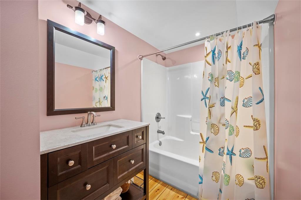 148 1st Street Georgetown, PA 15043 - Photo 29 of 48 a bathroom with a granite countertop sink a mirror a shower and a bathtub