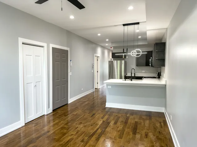 a view of kitchen with center island wooden floor and living room
