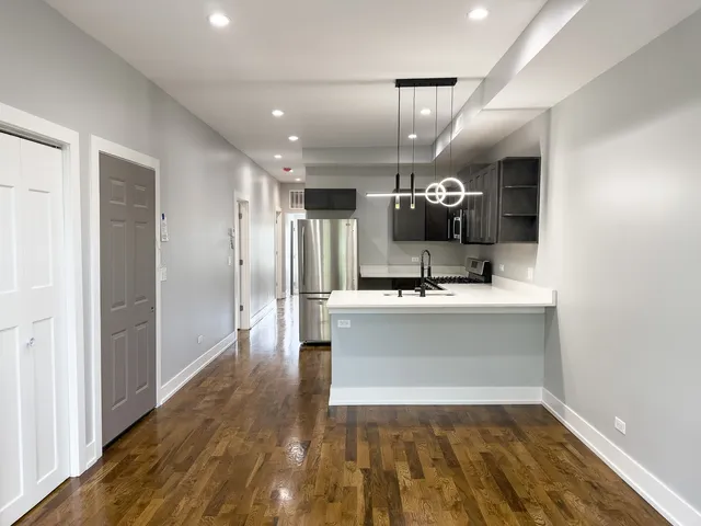 a view of kitchen with a sink and refrigerator
