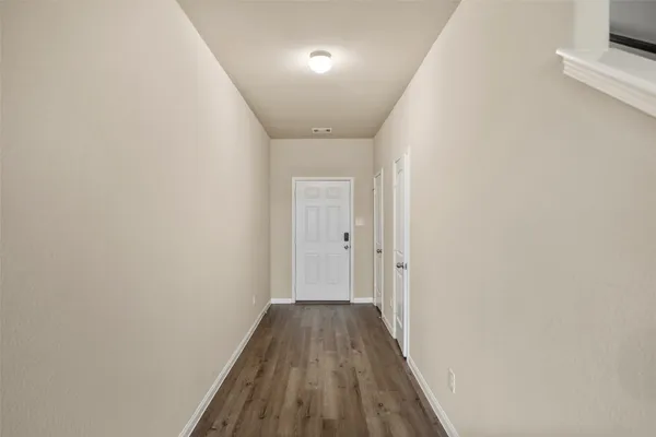 a view of a hallway with wooden floor