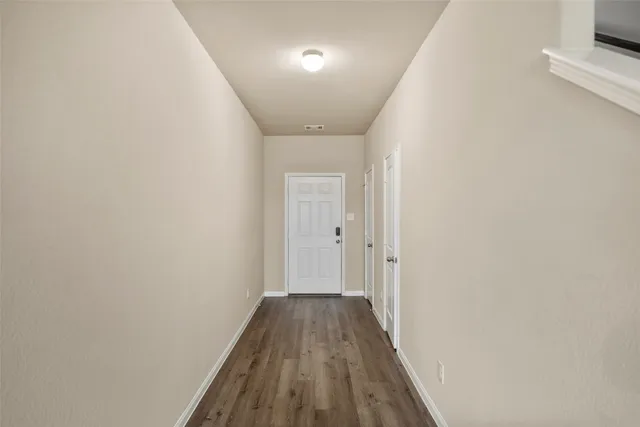 a view of a hallway with wooden floor