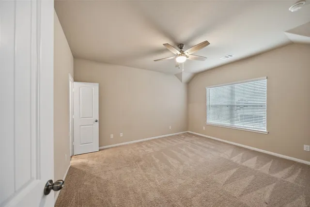 a view of a big room with windows and chandelier fan