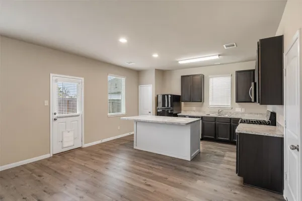 a kitchen with a sink cabinets and wooden floor