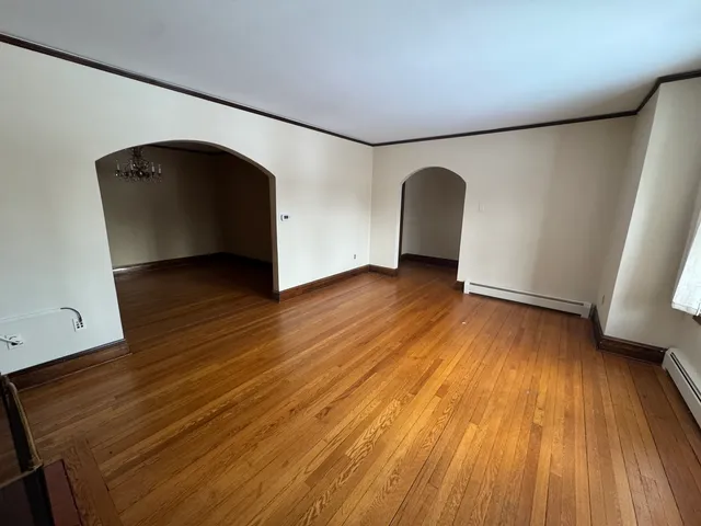 a view of a livingroom with wooden floor and chandelier