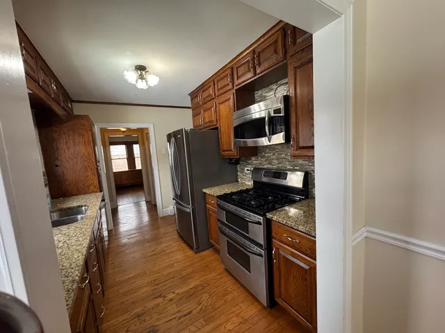 a kitchen with stainless steel appliances granite countertop a stove refrigerator and microwave