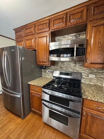 a kitchen with granite countertop a stove and a refrigerator