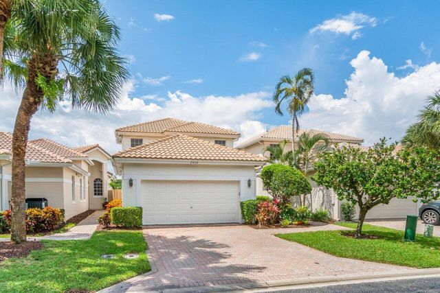 a front view of a house with a garden and a garage