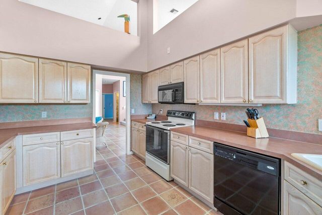 a kitchen with white cabinets stainless steel appliances and a sink