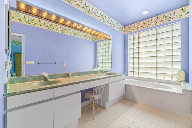 a bathroom with a granite countertop sink and a large mirror