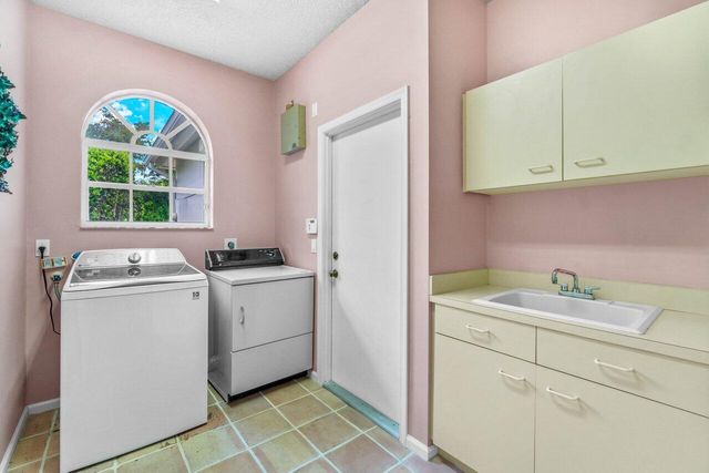 a utility room with sink dryer and washer