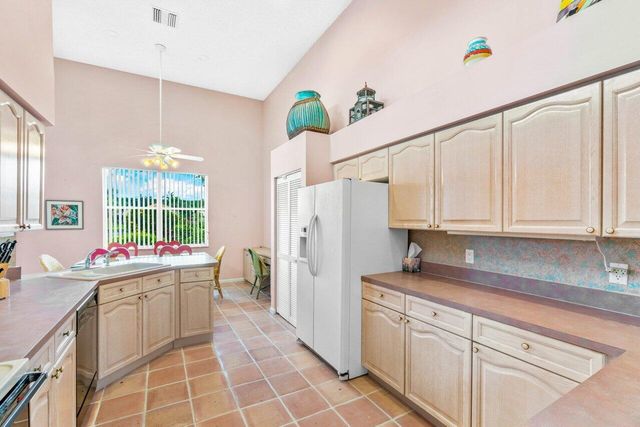 a kitchen with a white cabinets and window