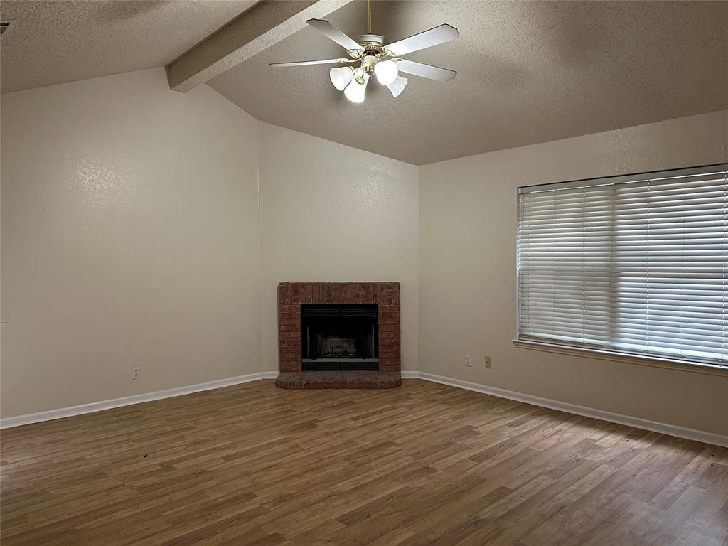 7629 Misty Ridge Drive North Fort Worth, TX 76137 - Photo 12 of 16 a view of an empty room with a window and a fireplace