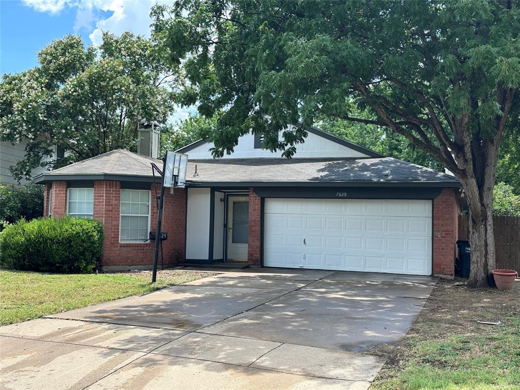 7629 Misty Ridge Drive North Fort Worth, TX 76137 - Photo 3 of 16 a front view of a house with a yard and garage