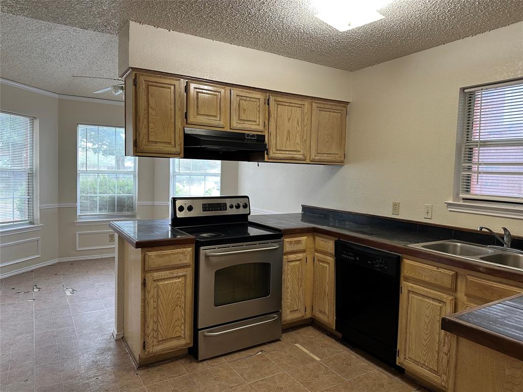 7629 Misty Ridge Drive North Fort Worth, TX 76137 - Photo 8 of 16 a kitchen with stainless steel appliances granite countertop a stove a sink and a microwave
