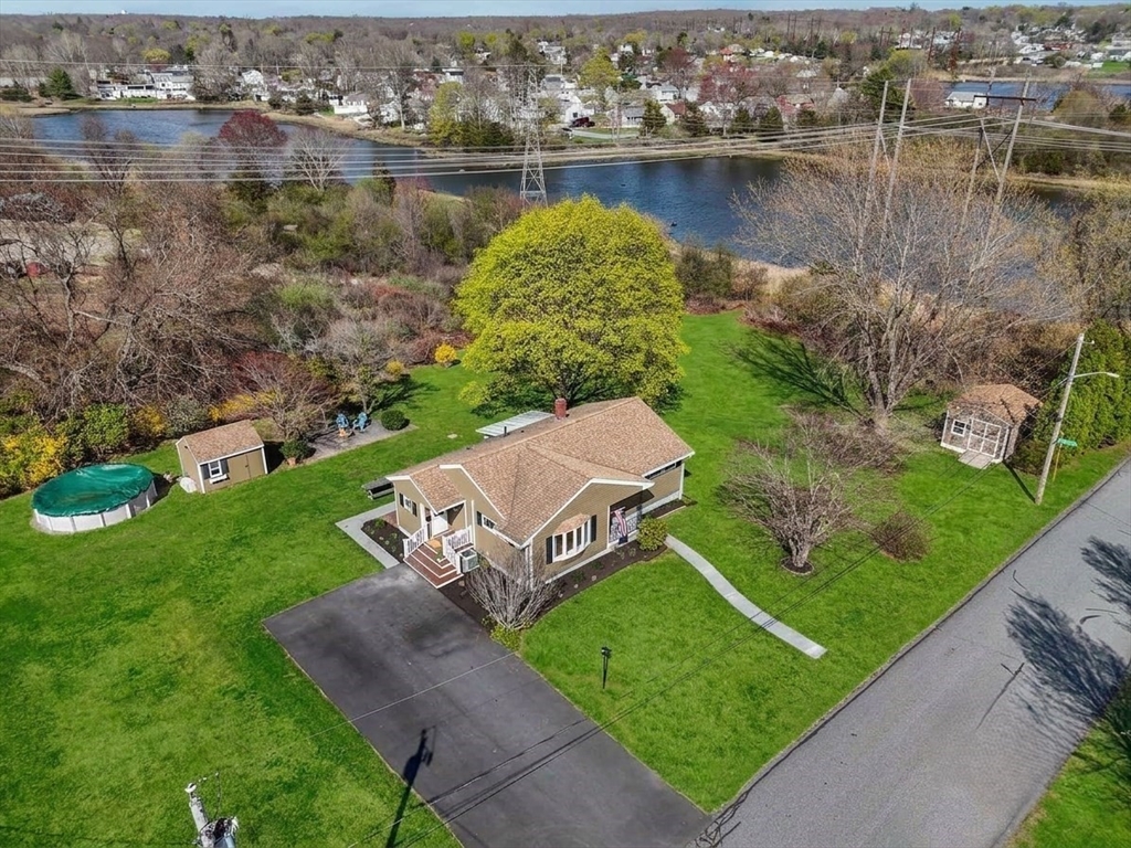 an aerial view of a house with garden space and lake view