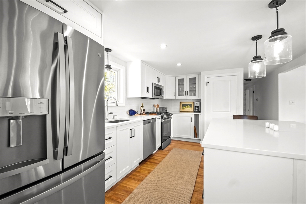 67 Montgomery Road Swansea, MA 02777 - Photo 4 of 41 a kitchen with refrigerator a microwave and white cabinets
