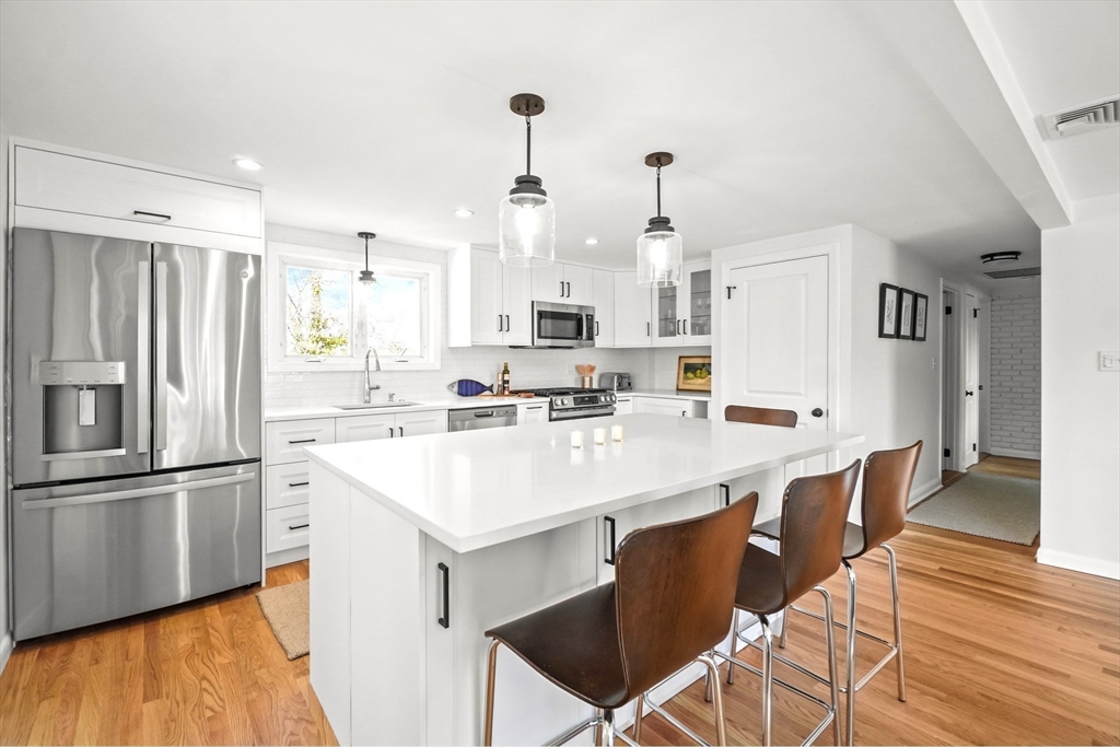 67 Montgomery Road Swansea, MA 02777 - Photo 5 of 41 a kitchen with stainless steel appliances kitchen island granite countertop a sink a stove a refrigerator and island with wooden floor