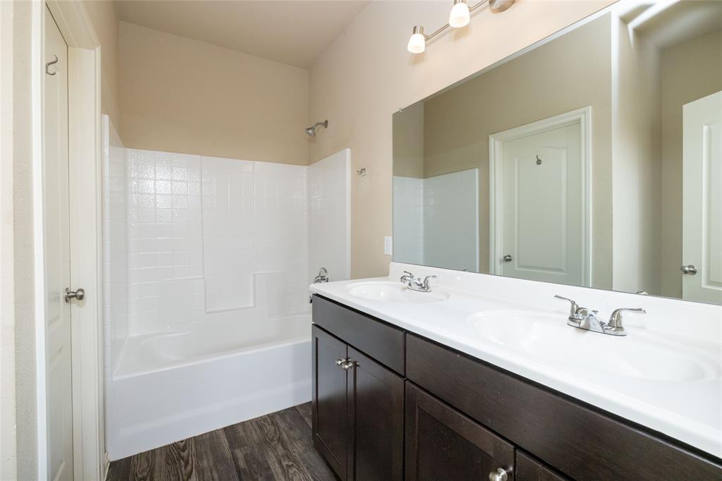 121 Mitchell Circle Terrell, TX 75160 - Photo 11 of 26 a bathroom with a tub sink double vanity and a mirror