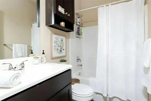 a bathroom with a sink a toilet a mirror and shower