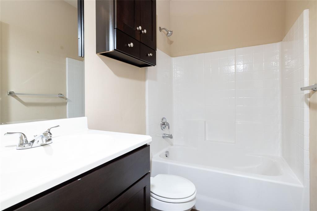 121 Mitchell Circle Terrell, TX 75160 - Photo 16 of 26 a bathroom with a bathtub a sink a toilet and a mirror