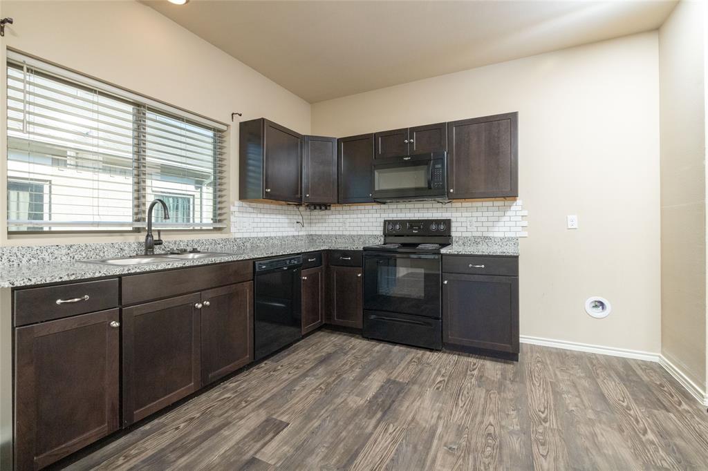 121 Mitchell Circle Terrell, TX 75160 - Photo 6 of 26 a kitchen with stainless steel appliances granite countertop a stove a sink and a microwave
