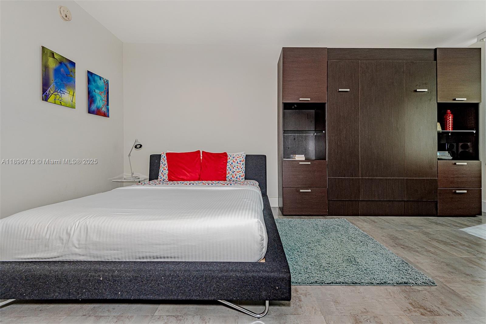 2301 Collins Avenue, Unit 723 Miami Beach, FL 33139 - Photo 12 of 26 a bedroom with a bed and a cabinets