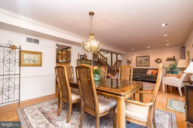 a dining room with furniture a chandelier and wooden floor