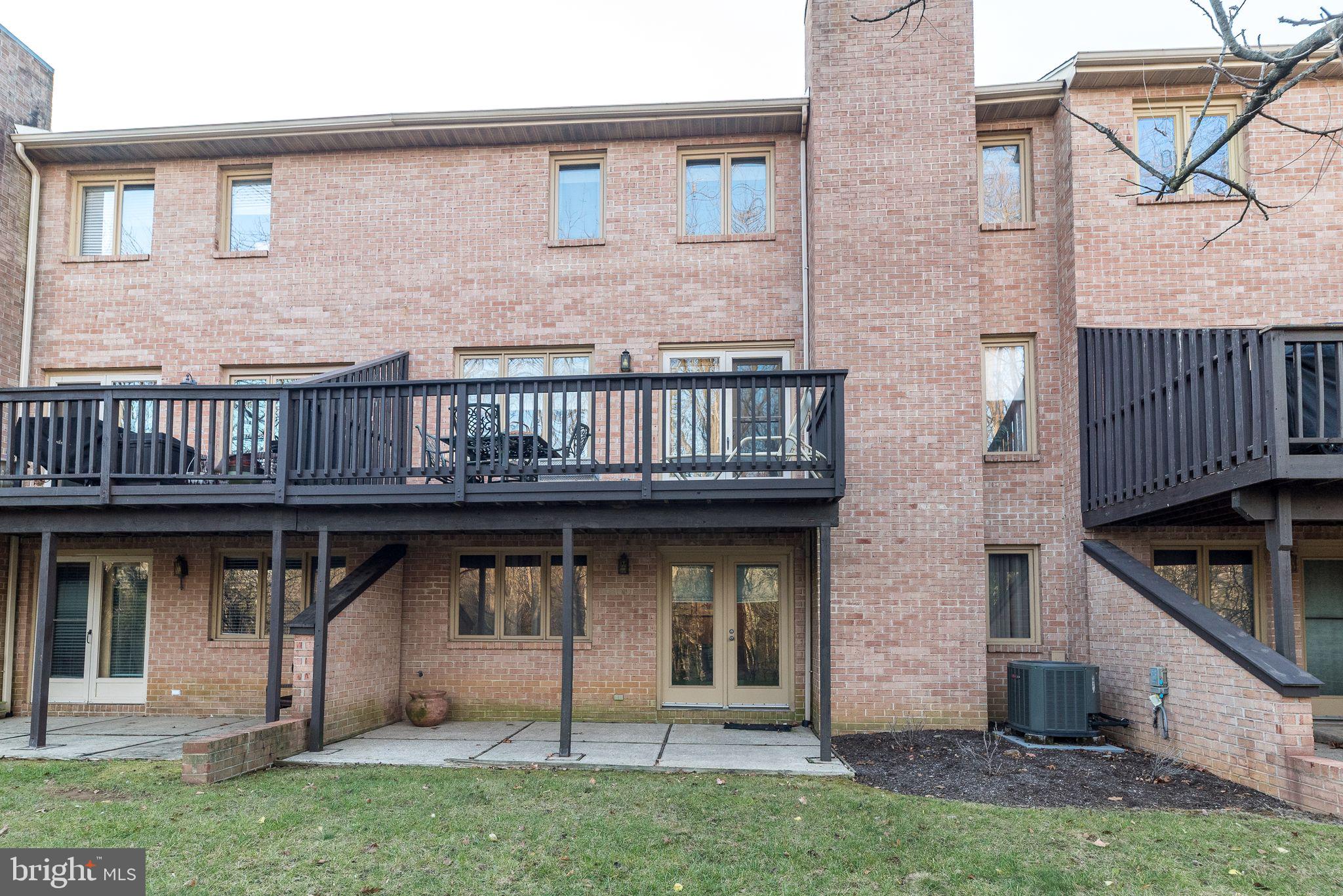 68 Amity Drive Chesterbrook, PA 19087 - Photo 55 of 62 a view of a brick house with many windows and a yard