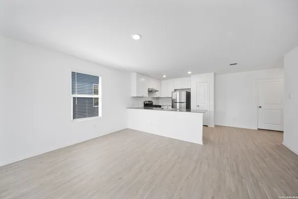 a view of a kitchen with wooden floor and windows