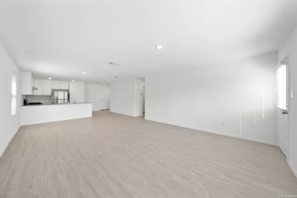 a view of kitchen with kitchen island white cabinets and wooden floor