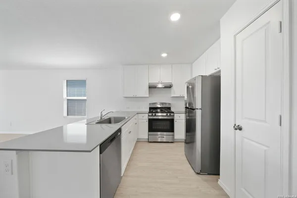 a kitchen with a refrigerator a sink and a stove