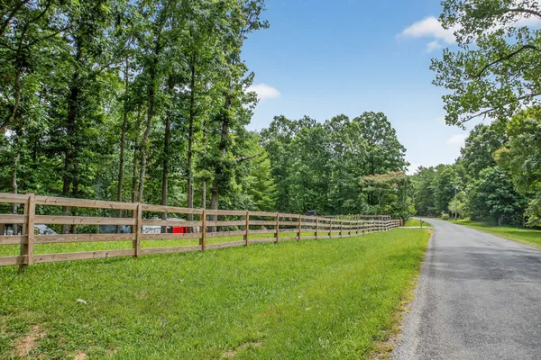 a view of a pathway of a park with wooden fence