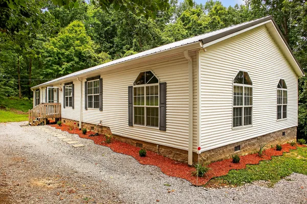 a view of a house with a yard and wooden fence
