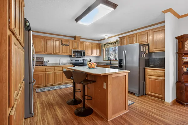 a kitchen with stainless steel appliances a refrigerator a sink a stove and cabinets