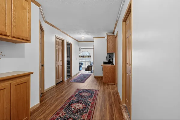 a view of a hallway with wooden floor and staircase