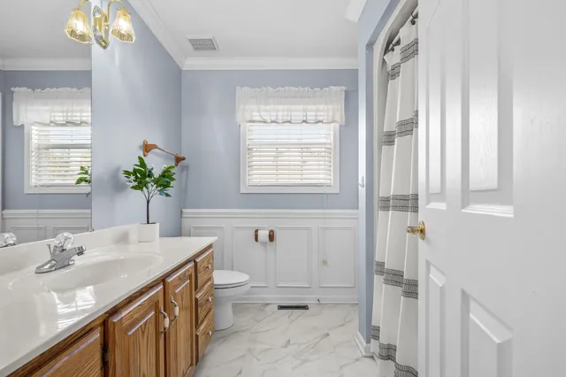 a view of a hallway with wooden floor and a kitchen